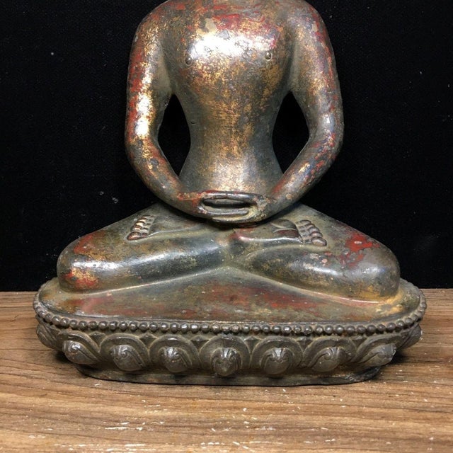 This is a serene and beautifully patinated Chinese bronze figure of Shakyamuni Buddha. The Buddha is seated in the...
