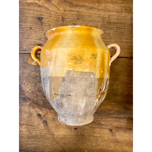 19th-century French terracotta confit pot with a warm ochre -yellow glaze and traditional double handles. Originally used...
