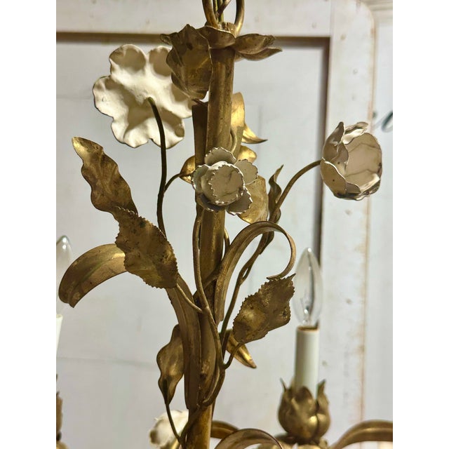 Illuminate your space with the timeless elegance of this vintage 16-light Italian gilded tole and cream enamel floral...