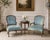 These vintage French Provincial Louis XV–style armchairs have carved giltwood frames, cabriole legs, and a low, wide...