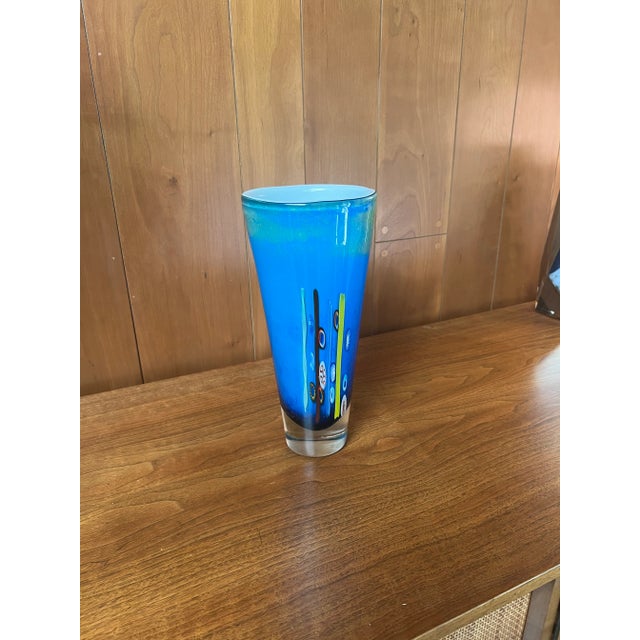 Vintage twentieth century modern art glass vase with brightly colored inclusions. The vase is cased glass with pieces of...