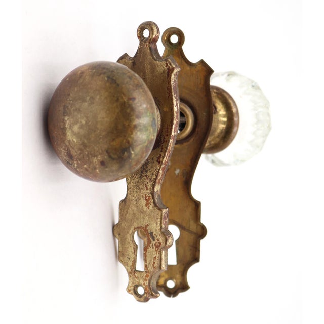 Traditional style passage door knob set made of brass and clear glass knobs with pressed brass back plates. Priced as two...