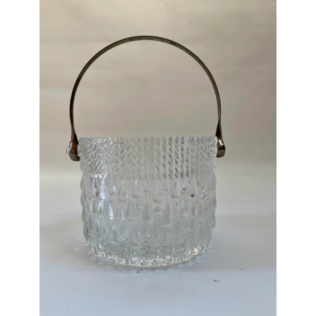 Mid-century modern glass ice bucket with silver-plate handle designed with an all-over tear drop motif by Iittala, made in...