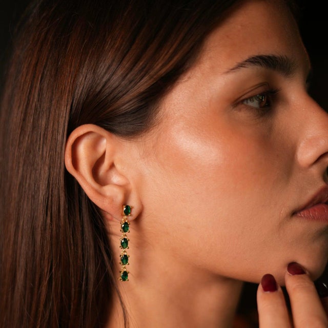 Illuminate your look with the Drop Down Green Emerald Earrings , featuring elegant 24k gold-plated frames that house...