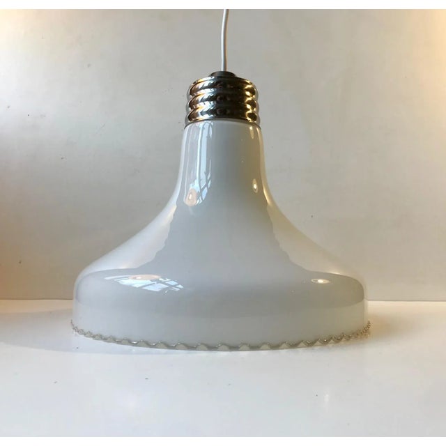 A rather large Danish hanging lamp composed of an opaline glass shade set in a fluted chrome plated steel socket. The...