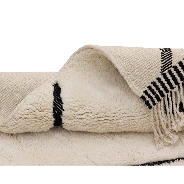 Elegant hand-knotted wool rug featuring a dynamic geometric pattern in Midnight Black and Ivory, creating a minimalist yet...