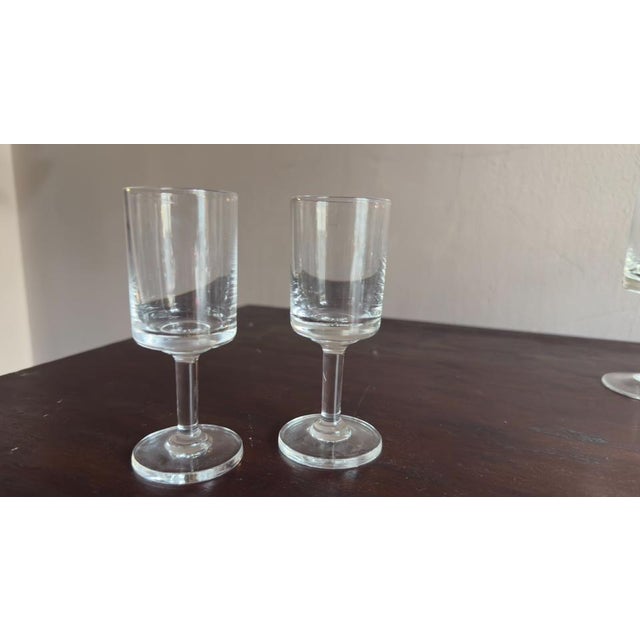 The Regulus glasses feature a simple, refined design with a cylindrical bowl, a flat heavy base, a slender stem, and a...
