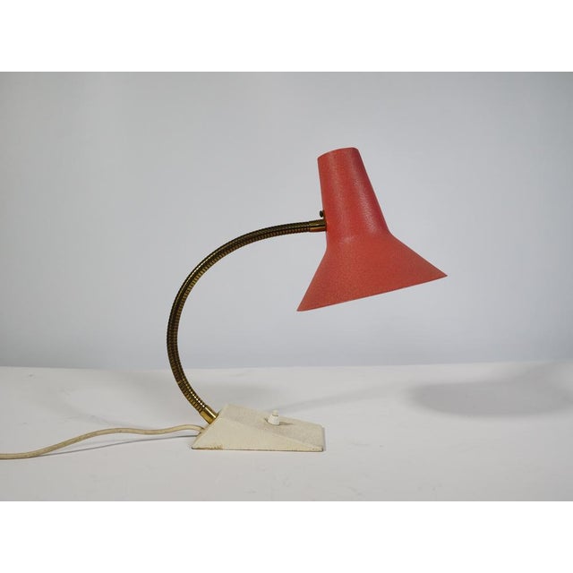 Mid-century metal table lamp, 1960s–70s. Conical, red lacquered metal shade with a light-colored interior and a flexible...