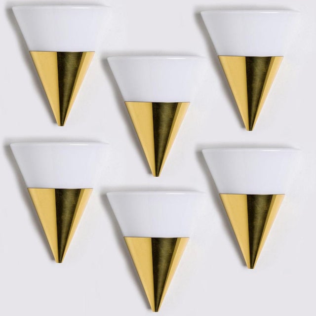 Cone shaped wall lights in white opaque glass with brass details. Manufactured by Glashütte Limburg in Germany during the...
