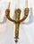 Pair of French Empire gilt bronze two-light sconces, 19th century, with a flame atop and empire faces design