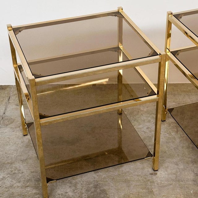 An elegant pair of vintage three-tier side tables dating from circa the 1970s, combining clean architectural lines with...