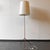 Product: floor lamp. Style: design. Probably 1980s. Material: tubular steel construction. Rust-red. Plastic lampshade....