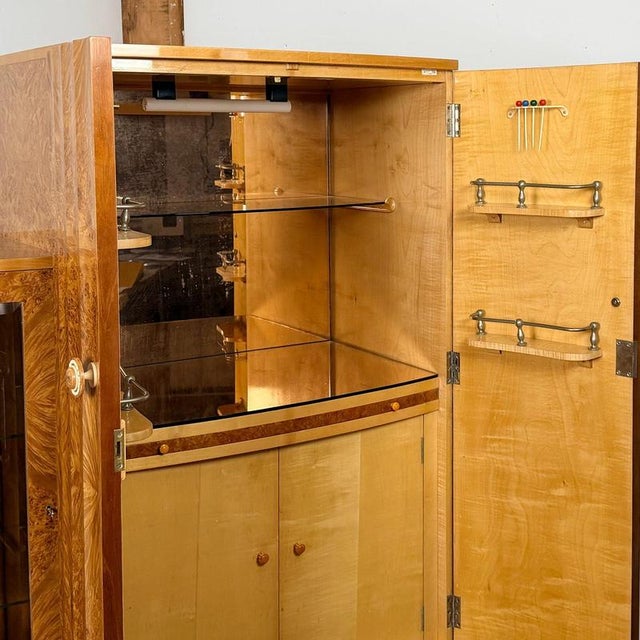 A superb art deco cocktail cabinet by harry & lou epstein. Central cocktail compartment opens to reveal a peach glass...