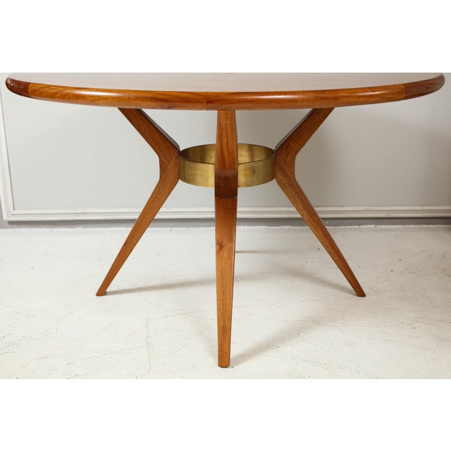 Italian Mid-Century Modern mahogany circular dining table/center table with central bronze ring on tripod base.