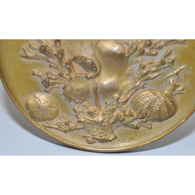 Beautiful underwater seascape by noted American sculptor Eliscu. One side shows various sea life, the other shows a...