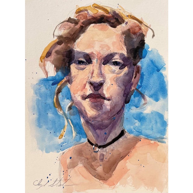 This watercolor portrait captures a figure with an expressive gaze, set against a vibrant wash of blue hues. The fluid...