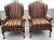 A pair of French style winged-back carved-wood and upholstered armchairs from the mid 20th century. This vintage pair of...