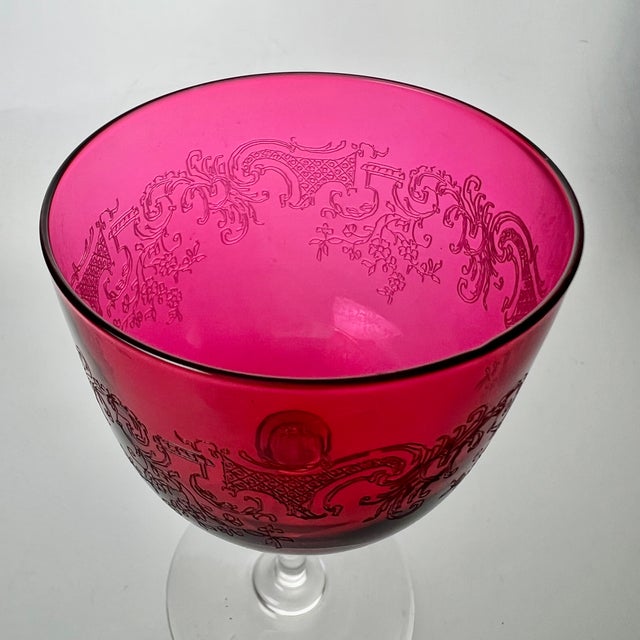 A stunning set of hand blown crystal stemware having vibrant fuchsia cups embellished with acid etched rococo style floral...