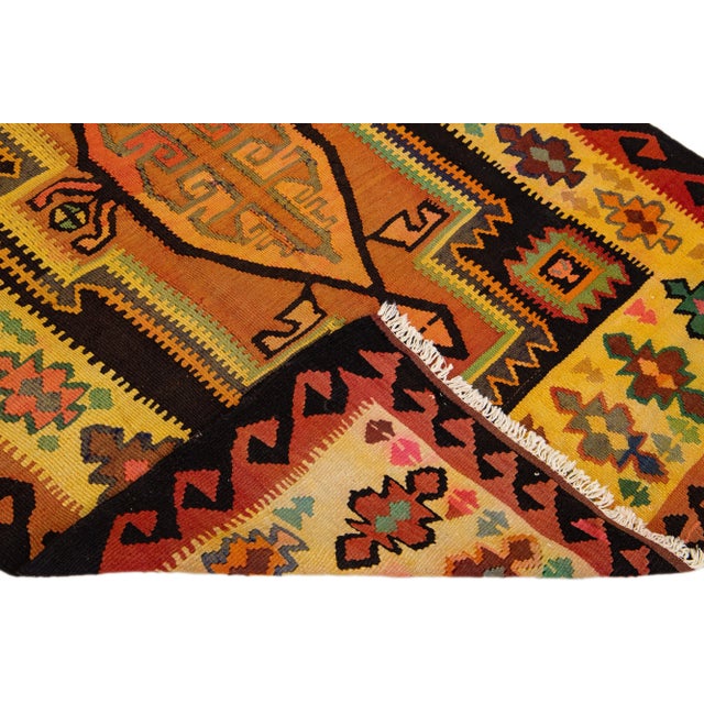 Beautiful vintage Turkish Kilim hand-knotted wool rug with a yellow field. This piece has a yellow frame and multicolor...