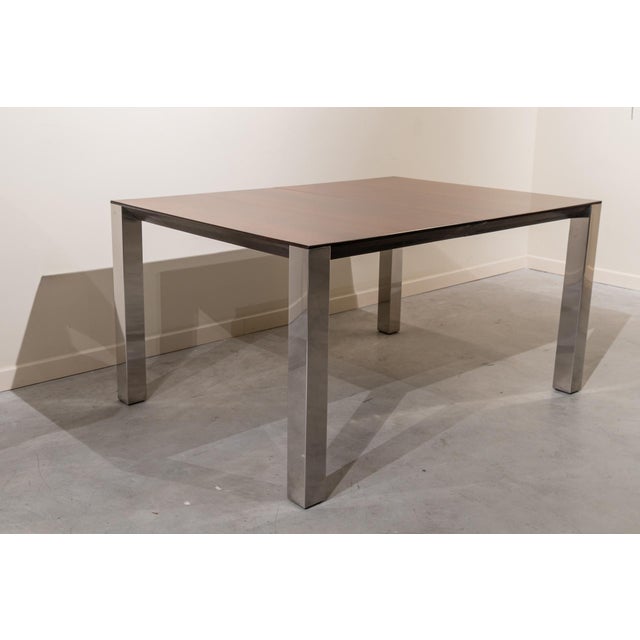 Italian extendable dining table from the 1970s. It features a rectangular frame with clean lines and proportions. It...