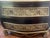 Striking bombe-form two-drawer chest with ebonized finish, gold-leaf trim, nailhead detailing, and richly embossed floral...