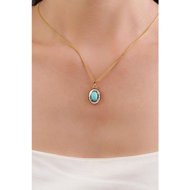 This Art Deco Inspired halo pendant showcase 1.43 carat natural oval turquoise, set in 14K yellow gold. The center stone...