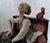 A detailed, hand-painted Italian polychrome porcelain figurine group depicting an elderly street musician/organ grinder...