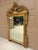 An elegant Italian giltwood mirror featuring a carved urn crest, foliate and rope swags, and Greeg key details. The...