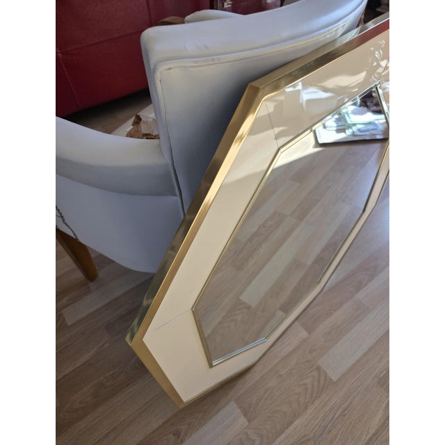 Large octagonal mirror designed and made by Jean-Claude Mahey in ivory-beige lacquer with brass moldings. French made,...
