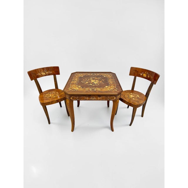 An exceptional circa-1970s Italian marquetry metamorphic game table with two matching inlaid chairs, concealing an...