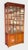 Tall Asian-or Chinoiserie-style display cabinet with a warm rosewood finish, glazed front and side panels, interior...