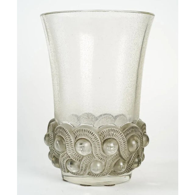 Vase in pressed molded glass and finishing of the body of the vase by sandblasting (frosted effect). Base decorated with...