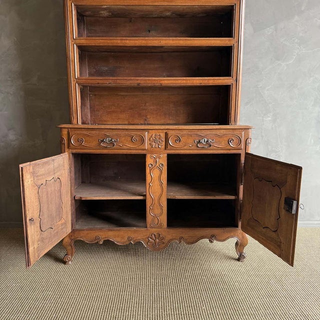 This antique French Provincial buffet deux corps is a classic piece crafted from solid oak with dovetail drawers and a...
