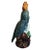 A tall bright ceramic bird sculpture in the style of Meissen. Glazed in blue, green, orange and brown polychrome, this...