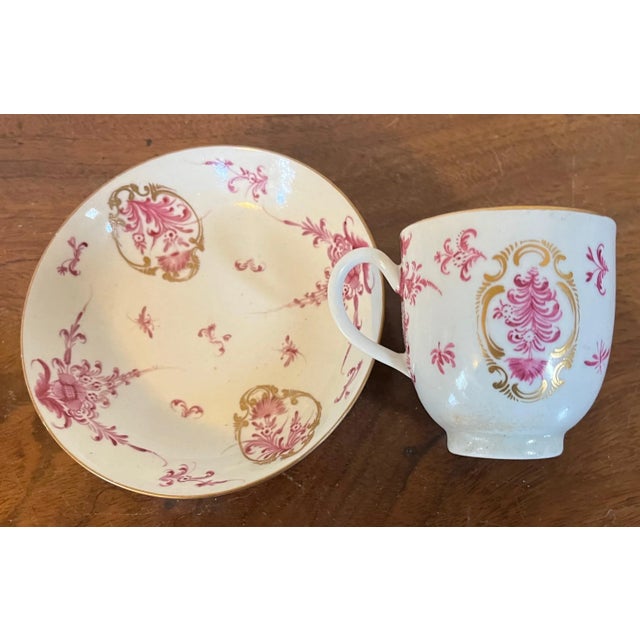 Antique 18th century German porcelain cup and saucer. Decorated with puce flowers enhanced by rich gilding. Saucer...