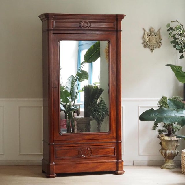 A single-door mirrored cabinet from the Louis-Philippe period, dating to the mid to late 19th century. The architecturally...