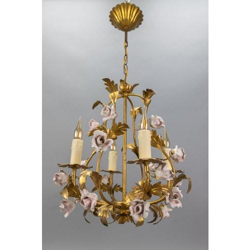 Hollywood Regency style gilt metal and pink porcelain roses chandelier, Italy, circa the 1970s. This stunning four-light...