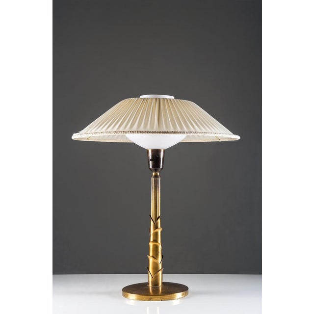 Very rare sculptural Swedish table lamp in brass, dating to the 1950s. The design is distinguished by its decorative...