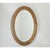 A opulent and intricately carved French 19th Century Napoleon III style giltwood oval mirror that will instantly transform...