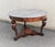 Round mahogany table featuring three lion-shaped carved uprights, joined at the base by an inlaid top. Contemporary gray...