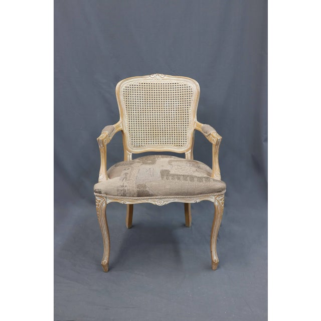 This vintage weave back armchair has a patterned gray upholstery edged with lace, and cabriole legs with distressed paint....