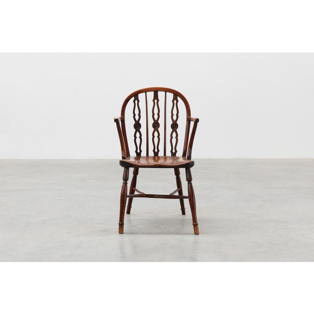 Windsor-style armchair with turned,solid seat. Good, sturdy condition with an old patina to the wood. This fine...