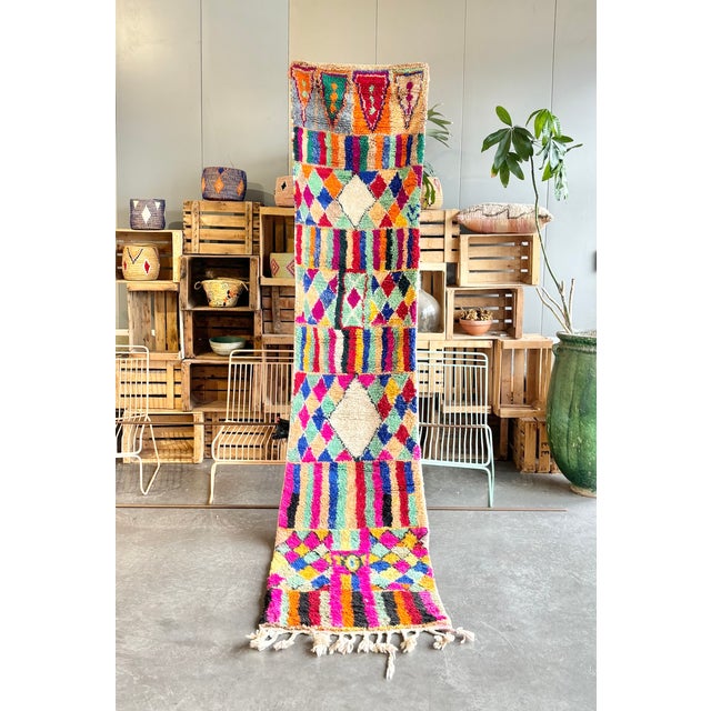This striking Moroccan Boujad runner rug is a vibrant expression of Berber artistry, handwoven using 100% natural wool by...