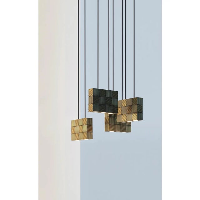 Hanging lamp in massive messing or brass covered with grooved lined tiles in checkerboard pattern. With two suspension...