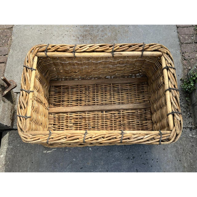 Old French toe or willow basket for storing items or as a basket for logs, circa 1940. It has a lived-in appearance and is...