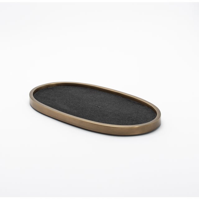 The Kifu Paris Oval Tray in black shagreen exemplifies contemporary luxury with its textured, hand-crafted surface and...