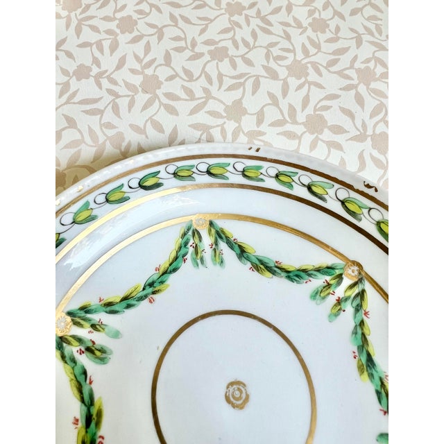 A refined porcelain low bowl by Royal Worcester, featuring a hand painted leaf swag motif. The soft ivory glaze and...