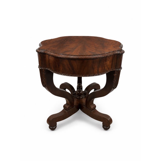 A striking restored burled wood table with a richly figured bookmatched top, sculptural shaped apron, and elegant scrolled...