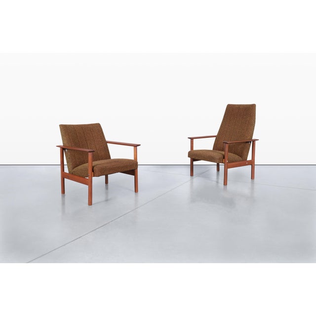 A pair of exquisite mid-century modern teak lounge chairs, crafted in Denmark during the iconic 1960s. These stunning...
