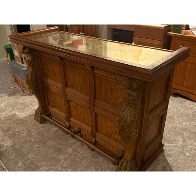 Vintage Pulaski Keepsake Collection Oak Wood Bar with carved Griffins, brass top and brass foot rail. Three oak doors with...